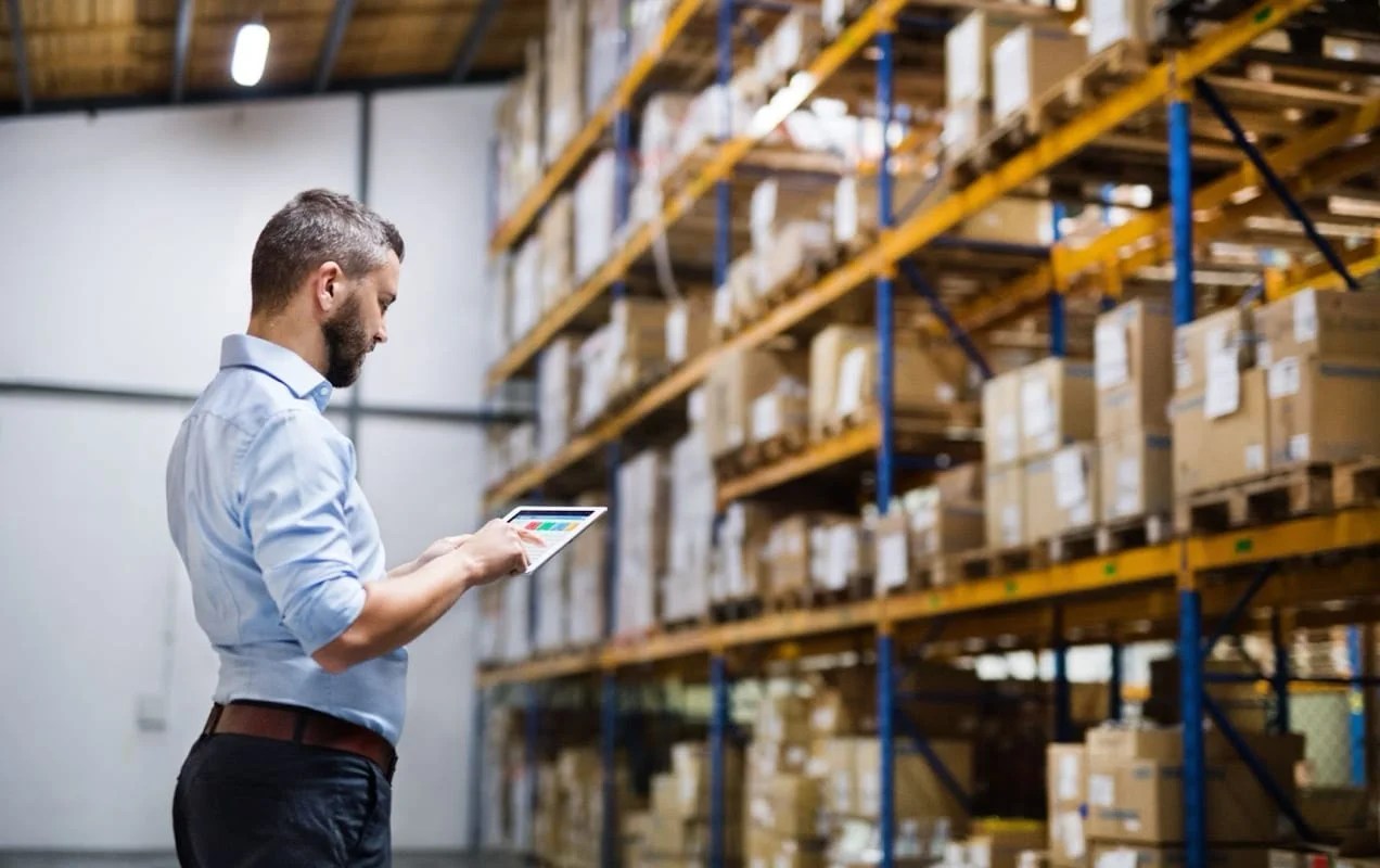 man working on a tablet in a warehouse