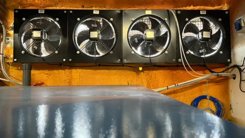 Four black ventilators rotate inside the SeaCURE facility in Weymouth. 
