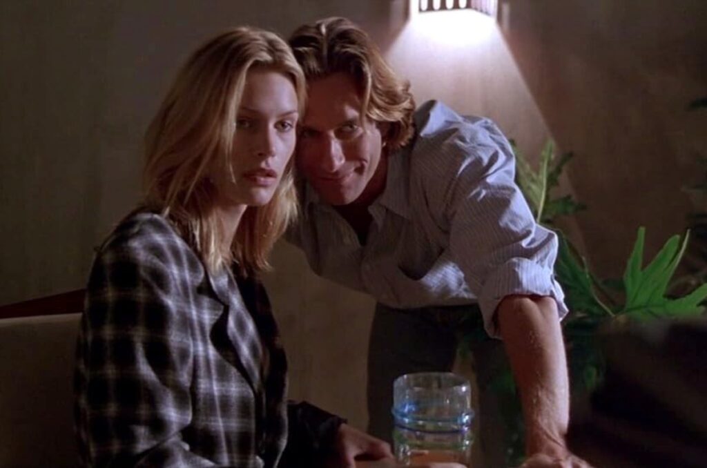 pretty blonde woman looking apprehensively at a camera while posing with a handsome man