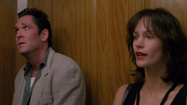 man and woman in an elevator looking straight ahead