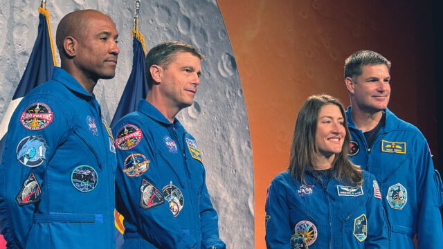 Three men and a woman, all in blue flight suits, pose for a photograph backdropped by images of the moon and Mars
