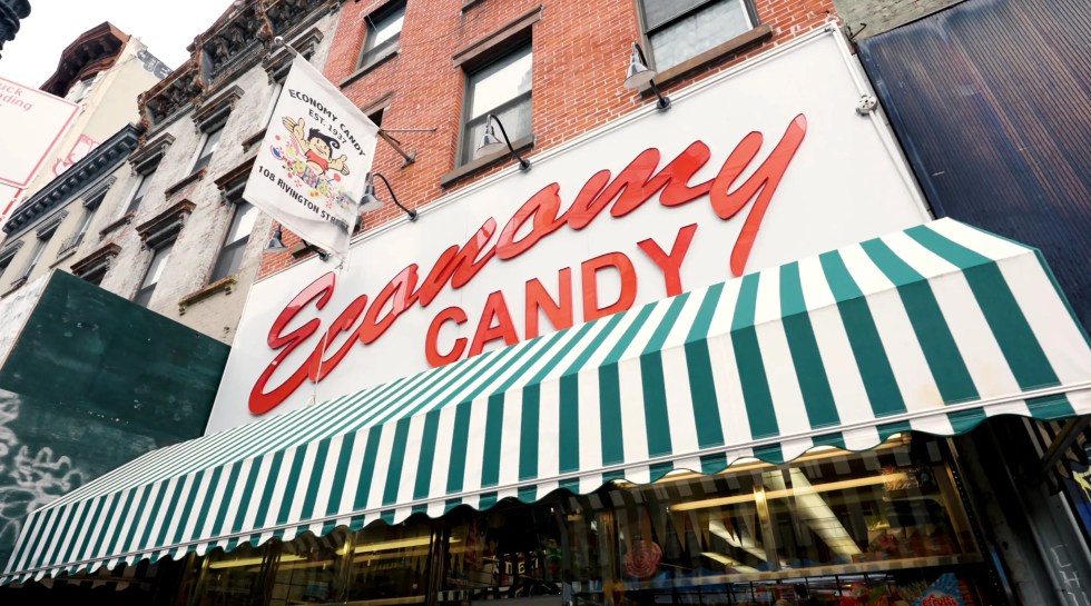 New York City: A white and green striped storefront awning below a white sign with red text reading "Economy Candy"