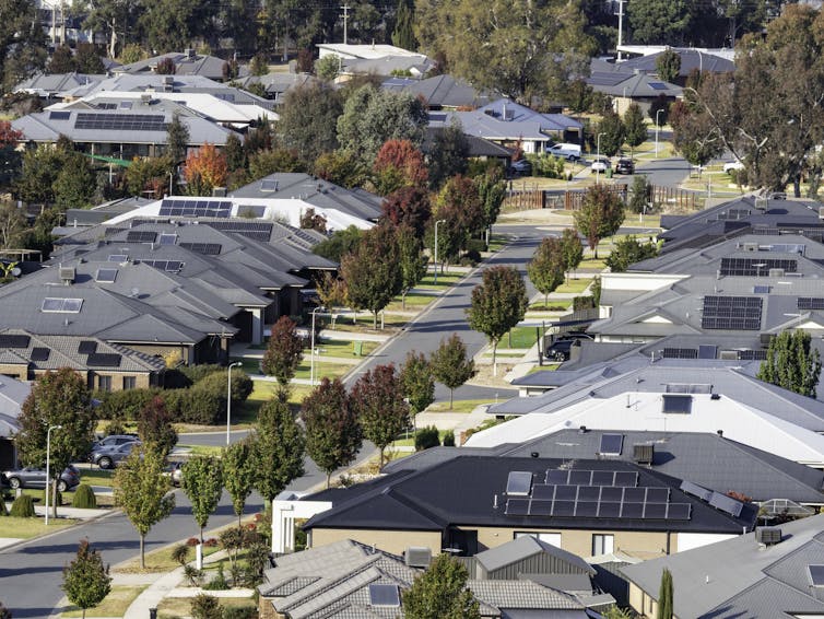 A suburban street, with solar panels visible on the houses.