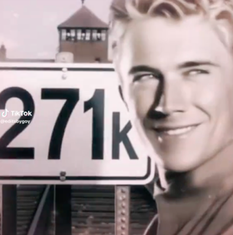 A smiling man in front of a sign reading 271k.