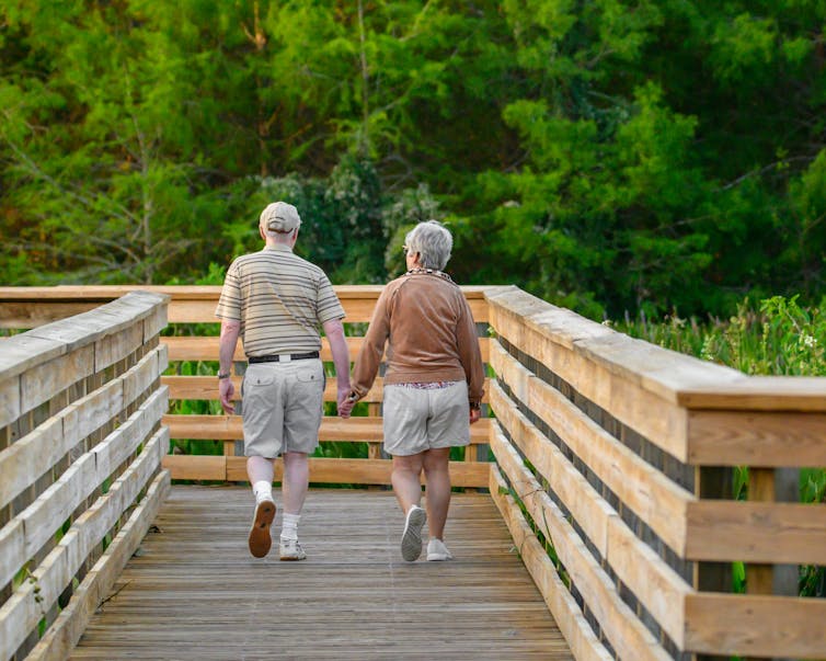 A senior couple walking along a boardwalk
