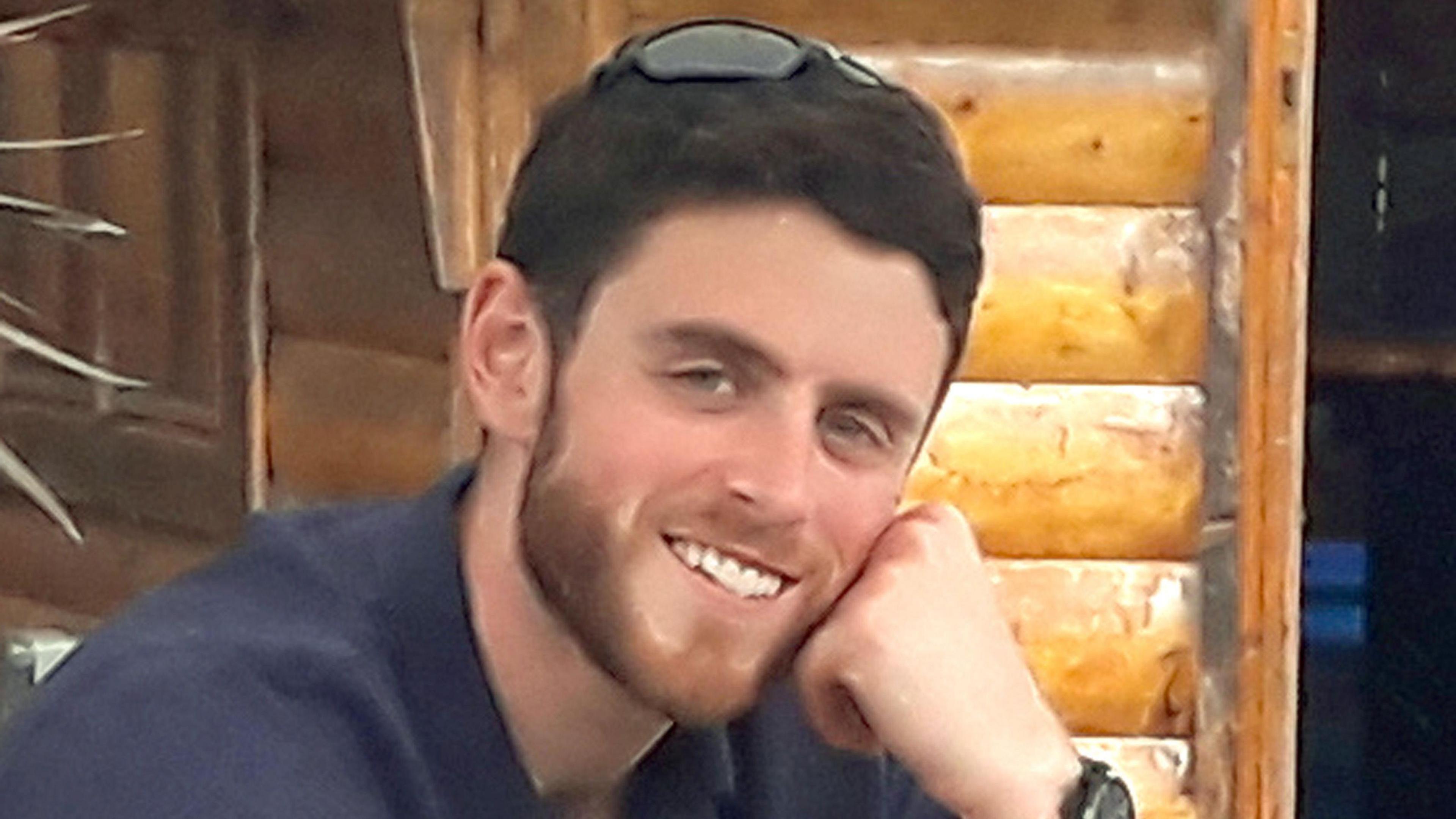 Andrew Harper is pictured - he is a man with short brown hair and a slight beard wearing a shirt and smiling at the camera.