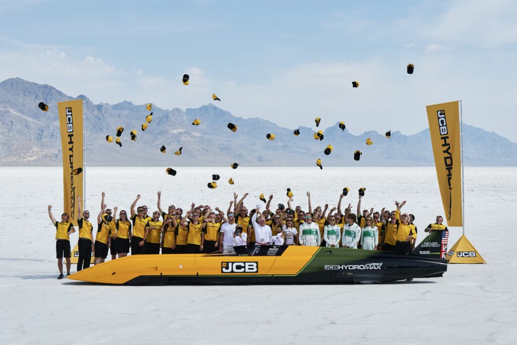 People celebrate next to a land speed car.