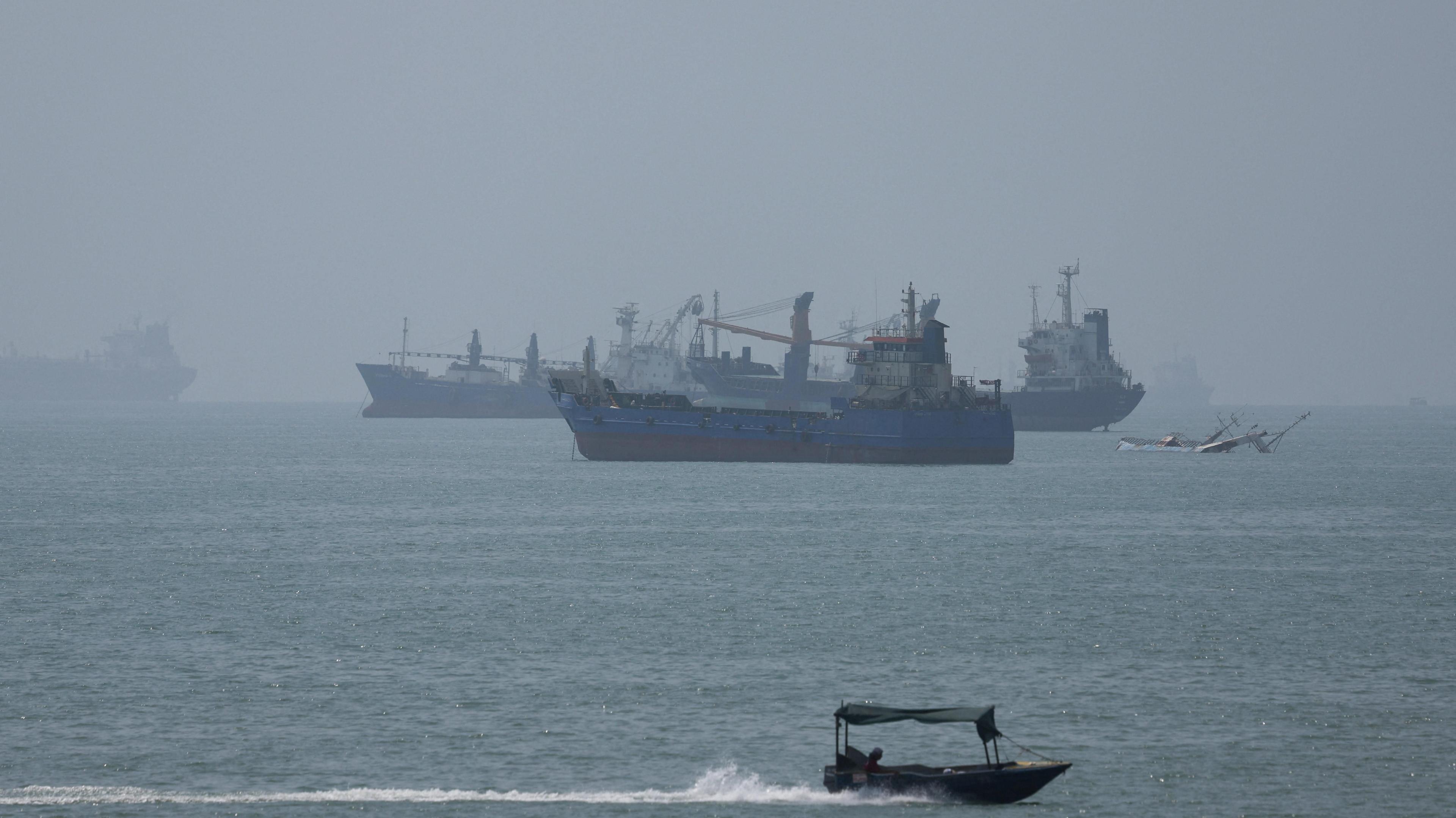 Large ships in the Strait of Hormuz are visible near the beach of Bandar Abbas.