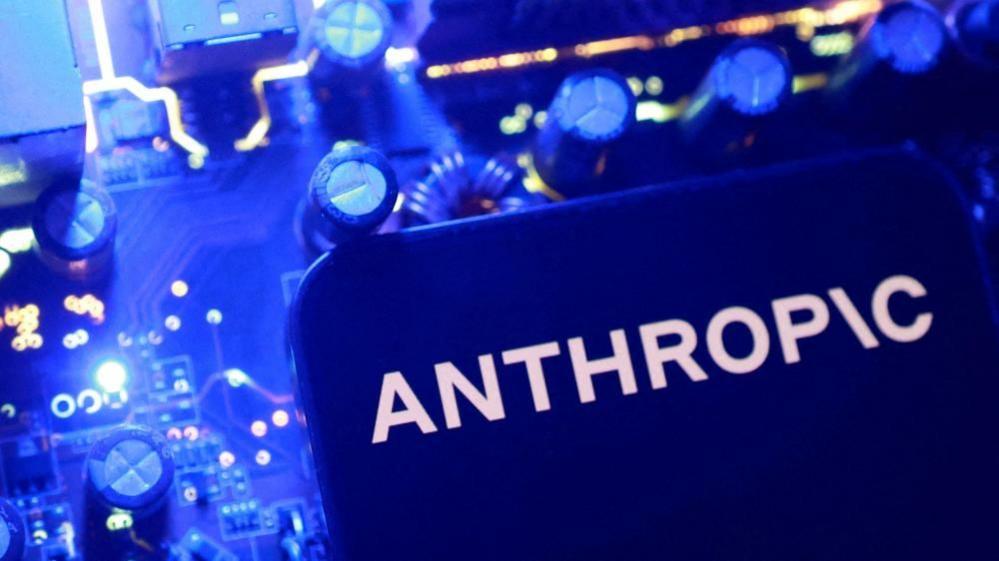 A blue Anthropic logo on a flat surface with blue nobs and dials in the background.
