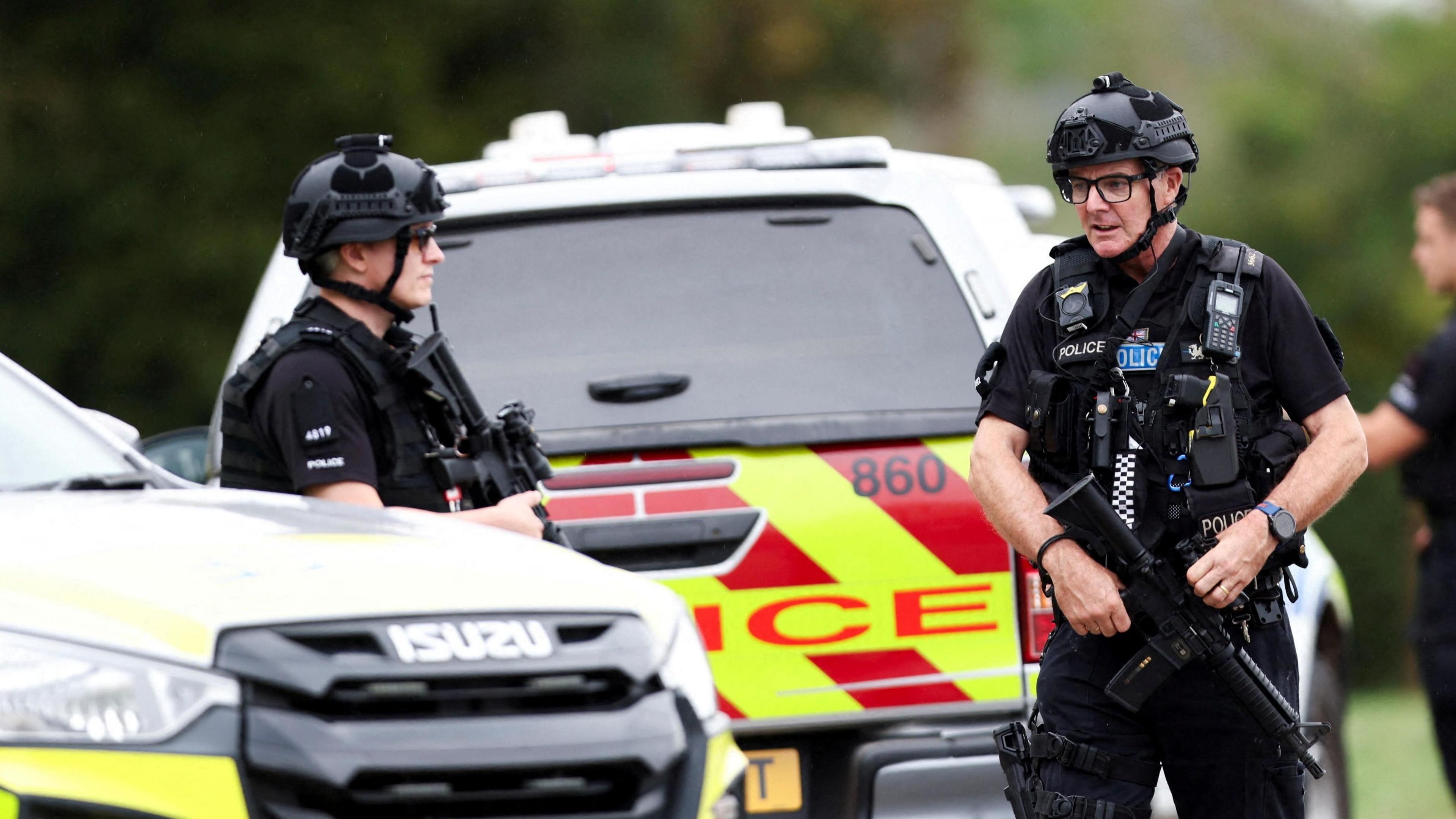 Armed police officers work on a road outside the perimeter of the RAF Fairford airbase
