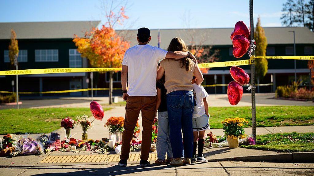 Community members grieve at the site of a makeshift memorial in front of Silver Rail Elementary School on October 16, 2026 in Bend, Oregon.