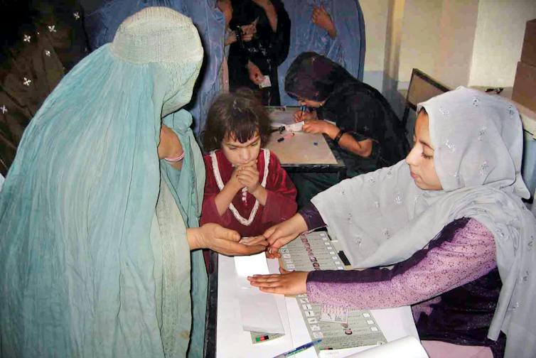 A woman casts her vote at a polling station in Kandahar.